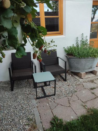 two chairs and a table in front of a house at Schoberkurve in Raubling