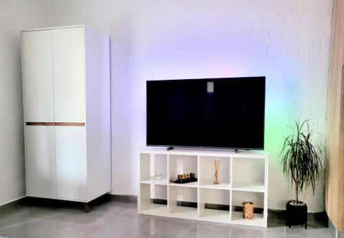 - une télévision sur un support blanc dans une pièce dans l'établissement studio Square Funtana, à Funtana