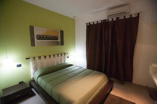 ein Schlafzimmer mit einem Bett in einem Zimmer mit grünen Wänden in der Unterkunft Imperial in Milazzo
