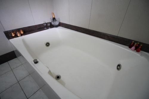 a white bath tub in a bathroom with at STATUS Motel in Belo Horizonte