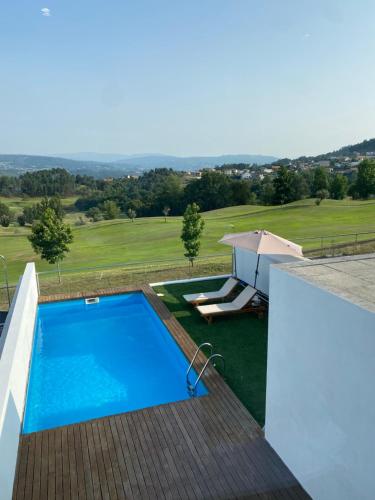 una piscina al lado de una casa en Moradia - Vila Golfe Amarante en Amarante