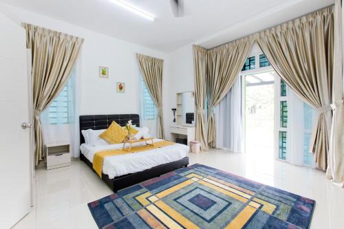 a bedroom with a bed and a large window at Desaru 16Pax Family with Private Mini Pool & Jacuzzi in Kota Tinggi