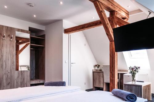 a bedroom with a bed and a flat screen tv at Heberer Hof in Schneverdingen