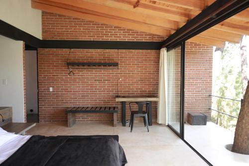 a patio with a brick wall and a table at Xomue in Valle de Bravo