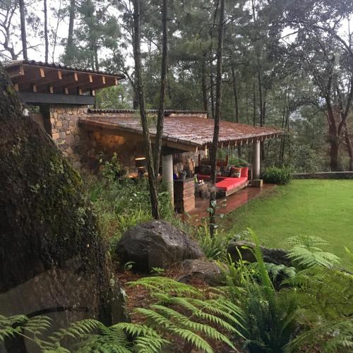 a house with a red couch in a yard at Xomue in Valle de Bravo