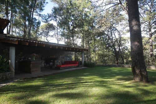 a patio with a red couch in a yard at Xomue in Valle de Bravo
