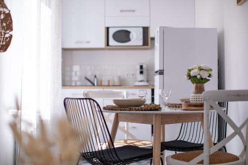 a kitchen with a table with chairs and a refrigerator at La Bouverie in Romans-sur-Isère