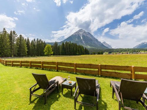 a group of chairs and a table in a field at Karwendel Berglodge in Leutasch