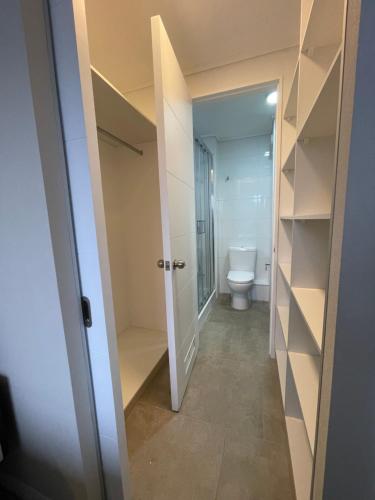 uma casa de banho com WC e um corredor com prateleiras em Epicentro Suites Apart Hotel - Valdivia em Valdivia