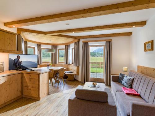 a living room with a couch and a table with a tv at Karwendel Berglodge in Leutasch