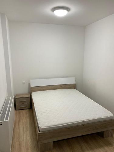 una piccola camera con un letto e una parete bianca di Cozy apartment IULIUS a Cluj-Napoca