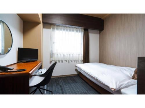 a hotel room with a bed and a desk with a computer at Hotel AreaOne Minamisoma - Vacation STAY 56229v in Minamisouma