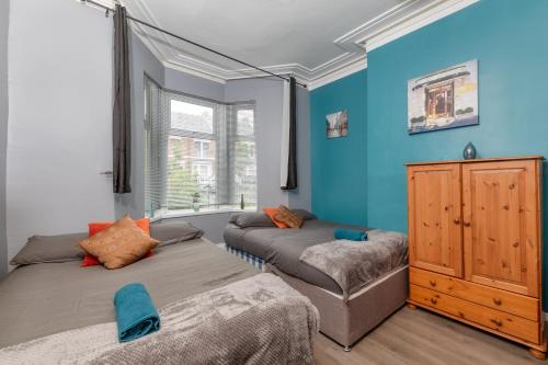 twee bedden in een kamer met blauwe muren bij Newcastle City Apartment free parking and wifi in Newcastle upon Tyne
