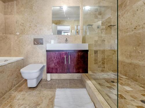een badkamer met een toilet, een wastafel en een douche bij Heated pool, Private garden, self check-in in Kaapstad