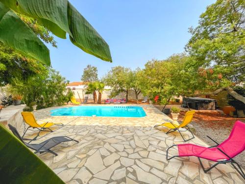a swimming pool with two chairs and a swimming pool at Villa Napoléon Piscine&Jacuzzi in Le Somail