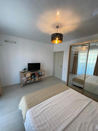 ein Schlafzimmer mit einem großen Bett und einem TV. in der Unterkunft Apartament Tino in Mamaia Nord – Năvodari
