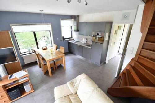 a living room with a table and a kitchen at Vrijvakantiehuis Houtenburgseweg 2 in Zoutelande