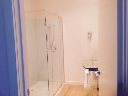 W łazience znajduje się szklana kabina prysznicowa i umywalka. w obiekcie Wytonia Beachfront Accommodation w mieście Port Fairy