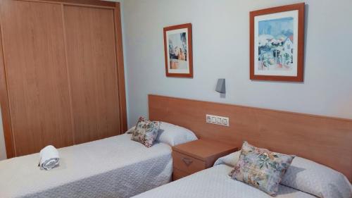 a hotel room with two beds and two pictures on the wall at Casa Tito in Campo Lameiro