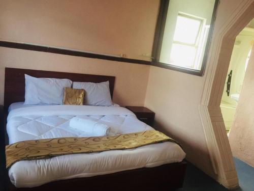 Un pat sau paturi într-o cameră la Elayo Trees Motel