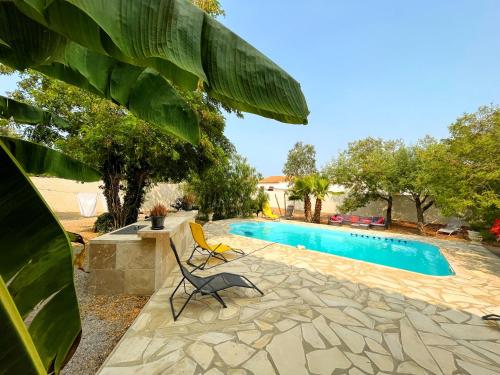 a chair sitting next to a swimming pool at Villa Napoléon Piscine&Jacuzzi in Le Somail