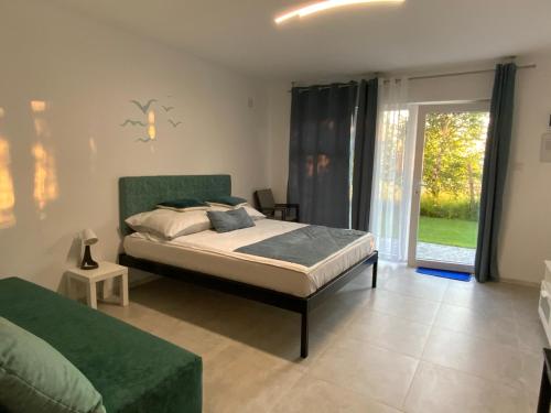 a bedroom with a bed and a sliding glass door at Pokoje Victoria in Ustka