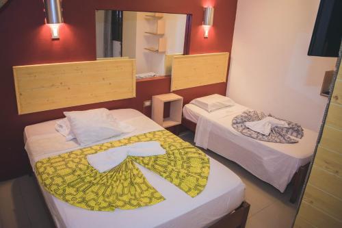 a room with two beds and a mirror at Hotel La Casona Iquitos in Iquitos
