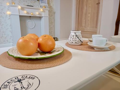 dwa pomarańcze na talerzu na blacie kuchennym w obiekcie Apartamenty Turystyczne WillkasSen w mieście Giżycko