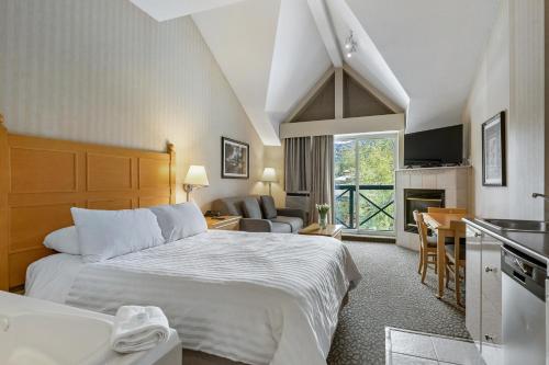 a hotel room with a large bed and a kitchen at Pinnacle Hotel Whistler in Whistler