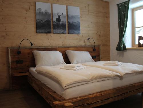 a bedroom with a large bed with three pictures on the wall at Seeblickhütte Lachtal in Niederwölz