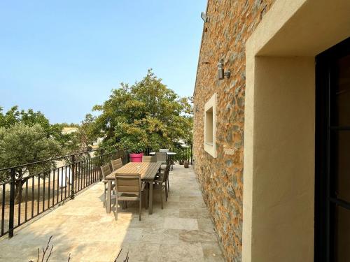 a patio with a table and chairs on a balcony at Villa Napoléon Piscine&Jacuzzi in Le Somail