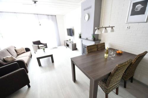 a living room with a table and a couch at Vrijvakantiehuis Houtenburgseweg 22 in Zoutelande
