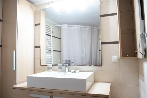 a bathroom with a white sink and a mirror at Lovos House in Laganas