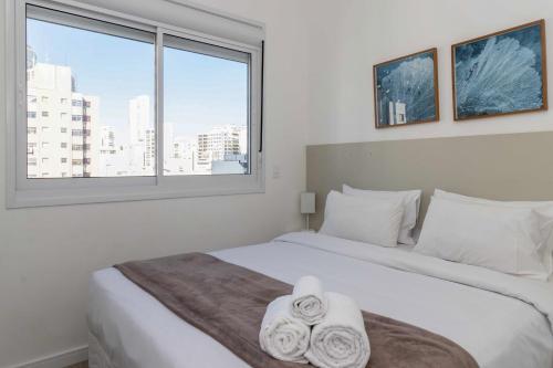 sypialnia z dużym białym łóżkiem i oknem w obiekcie 360 Higienópolis w São Paulo