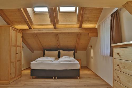 ein Schlafzimmer mit einem Bett in einem Zimmer mit Holzdecken in der Unterkunft Apartment SB77 Leogang in Leogang