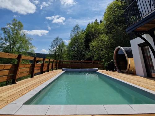 a swimming pool on a deck with a wooden fence at ATPeak Lodge Maison de Montagne d'exception in Xonrupt-Longemer