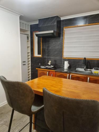 蓬塔阿雷納斯的住宿－feelings，厨房配有木桌和椅子