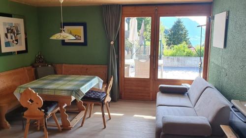 ein Wohnzimmer mit einem Tisch und einem Sofa in der Unterkunft Appartement Seelewärmerli - Balsam für Ihre Seele in Seelisberg
