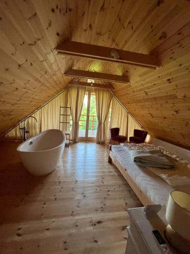 um quarto amplo com uma banheira e uma cama em CSENDÜLŐ VENDÉGHÁZ em Noszvaj