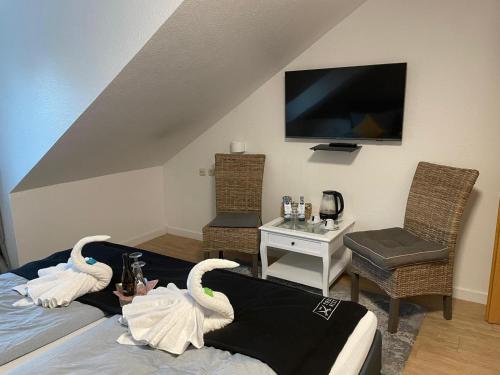 a living room with swans on the bed and a tv at Hotel und Restaurant zum bunten Hirsch in Mirow