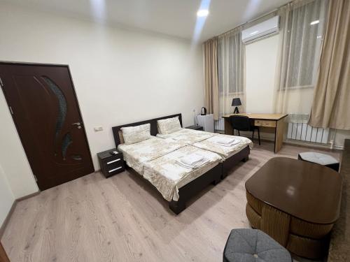 a bedroom with a bed and a desk in it at Arm Hotel in Yerevan