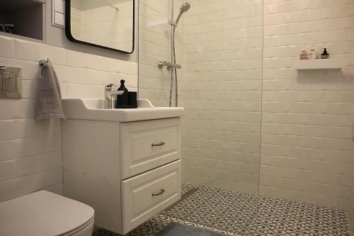 ein weißes Bad mit einem Waschbecken und einer Dusche in der Unterkunft Apartamenty nad Zalewem 213 in Serock