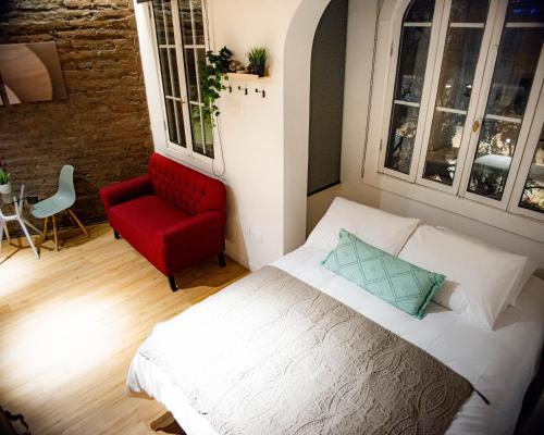 1 dormitorio con 1 cama y 1 silla roja en Loft Nuevo en Santiago, Barrio Lastarria, en Santiago