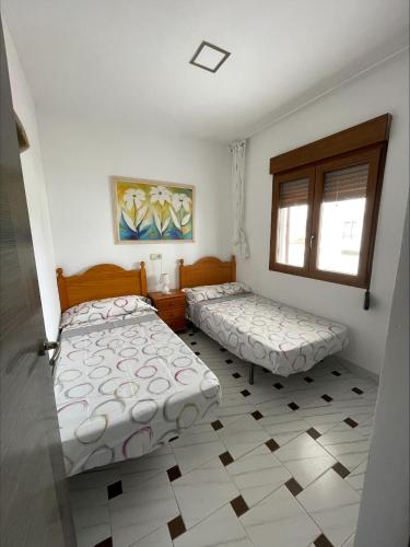 - une chambre avec 2 lits et une fenêtre dans l'établissement Edificio Guadalupe, à Alcossebre