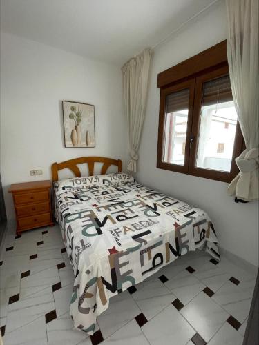- une chambre avec un lit et une couette noire et blanche dans l'établissement Edificio Guadalupe, à Alcossebre