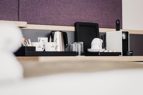 a shelf with cups and other items on it at Holiday Inn - Eindhoven Airport by IHG in Eindhoven