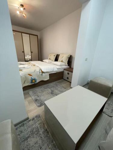 Habitación con 2 camas y mesa. en Apartament regim hotelier, en Caransebeş