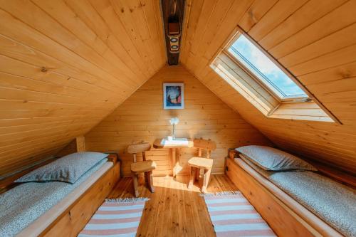 um quarto com 2 camas num chalé de madeira em Bieszczadzka Bania em Lesko
