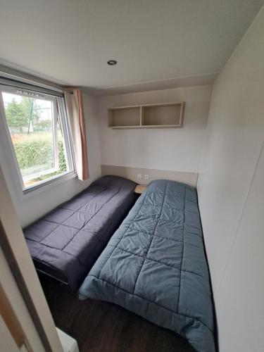 une petite chambre avec un lit et une fenêtre dans l'établissement Mobil Home neuf tout confort dans un camping 4 étoiles, à Onzain