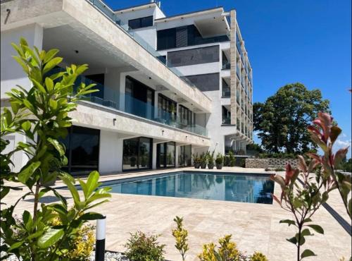 un edificio de apartamentos con piscina frente a él en Club Panorama Lake View Apartment, en Alsóörs